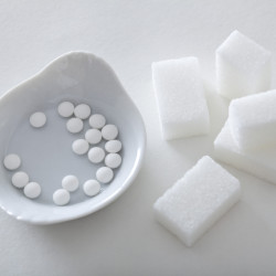 Artificial sugar next to natural sugar cubes
