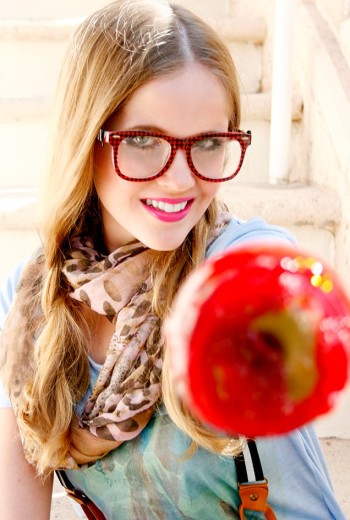 Lauren Poole wearing nerdy glasses eating apple