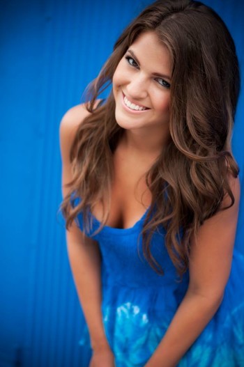 Michelle Concilio wearing a blue dress in a blue background
